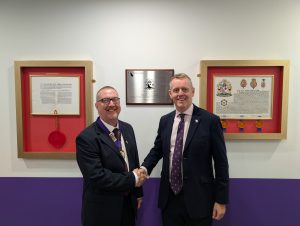 Dr Ian Higginson (left) is formally handed the presidency of RCEM by Dr Adrian Boyle (right).