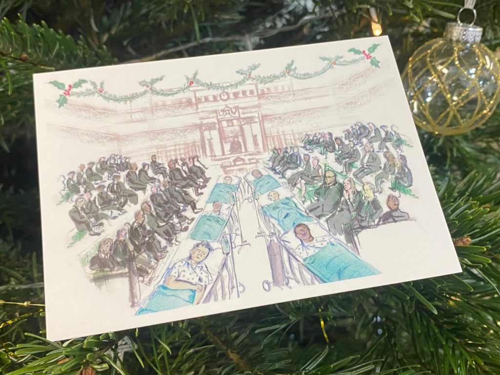 Front cover of the RCEM festive greeting card to all MPs. It depicts the House of Commons chamber, but in the middle there are two lines of patients in A&E trolleys.